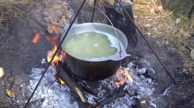 Yangında kazan var. Yürüyüşte yemek pişirmek. Kamp alanında yemek çorbası. Aşırı seyahat turizmi. Orman gezisi