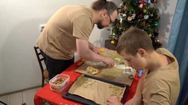 Noel kurabiyesi yapıyorum. Hamur masada. Erkek ve erkek çocuk birlikte yemek pişiriyor. Baba ve oğul yemek pişiriyor. Aile zamanı.