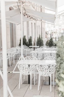 Outdoor Cafe caddesindeki boş masa ve sandalyeler. Bar restoranı Beyaz şemsiye veranda arka planı