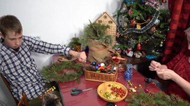 Çocuk kediyle oynuyor. Büyükannem Noel çelengi yapar. Yaşlı kadın ve genç kız kışın birlikte vakit geçirirler. Aile eğlencesi.