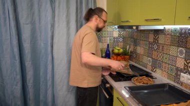 Adam kurabiye tepsisinden spatulayla birlikte bir tabağa koyar. Ev yapımı pişirme. Evde yemek pişir. Hamur işleri