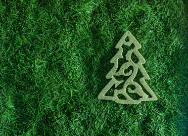 Arka planda yeşil iğneler olan Noel ağacı oyuncağı. Üst görünümü dekore et