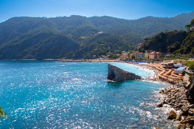 Yazın sahilde şemsiyeler. İtalyan bayramı. Ligurian Denizi ve Dağ Kayası kıyısında tatiller. Liguria Monterosso Doğa