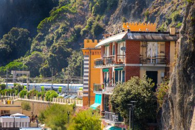 İtalyan sahilindeki sarı parlak ev. Pencerelerde panjurlar var. Eski renkli mimari