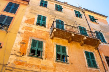Sarı evler binalar. Monterosso İtalyan köyü. Yeşil ahşap panjurlu pencereler dar sokak balkon mimarisi, Liguria, İtalya.