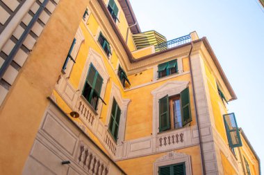 Sarı evler binalar. Monterosso İtalyan köyü. Yeşil ahşap panjurlu pencereler dar sokak balkonu mimarisi, İtalya.
