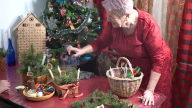 Büyükannem ve torunum birlikte Noel süsü yapıyorlar. Yaşlı kadın ve genç çocuk evi dekore ediyor. Aile aktiviteleri. Zanaat