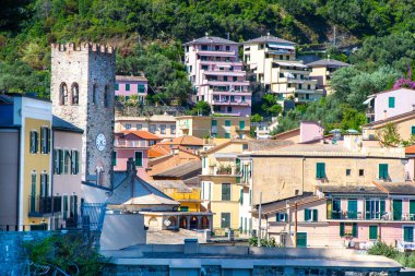 Monterosso Cinque Terre 'de çan çalıyor. Kilise kulesindeki saat. Renkli binalar İtalyan köyü dar sokak eski mimarisi İtalya mimarisi