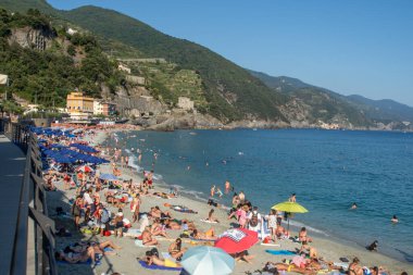 İnsanlar dinleniyor. Yazın sahilde şemsiyeler. Ligurian Denizi kıyısında İtalyan tatili. Liguria Cinque Terre. İtalya, Monterosso - 15 Temmuz 2025.