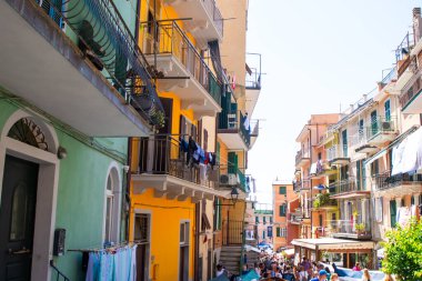 Dar sokaktaki parlak renkli balkon evleri. Manarola İtalyan köyü Liguria deniz kenti mimarisi UNESCO. Cinque Terre 'de. İtalya, Manarola - 15 Temmuz 2025.