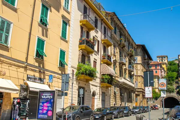 Araba parkı. La Spezia şehrindeki Houses caddesinde. İtalyan eski kasaba merkezi. Çiçekli eski balkon. İtalya, La Spezia - 15 Temmuz 2025