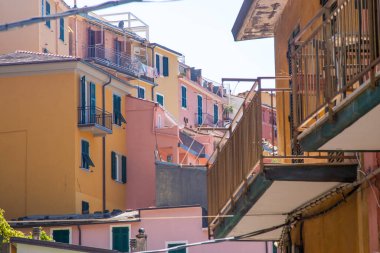 Pembe turuncu renkli evin balkonundaki İtalyan panjurları. Yazın ahşap kepenkleri açın. Mimari La Spezia şehir binası. Cinque Terre