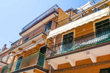 Balkon için tente şemsiyesi. Pencerenin önündeki İtalyan panjurları. Cinque Terre Manarola 'da eski bir evde yaz. Mimari bina cephesi.