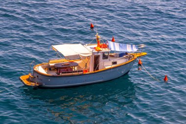 Mavi sularda küçük bir balıkçı gemisi, Ligurian Denizi. Teknenin adı Cinque Terre. İtalya, Manarola - 15 Temmuz 2025.