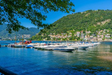 İtalya 'daki Como gölündeki rıhtımda tekneler. Limanda yatlar ve gemiler var. Yazın İtalyan doğası. İtalya, Como - 17 Temmuz 2025