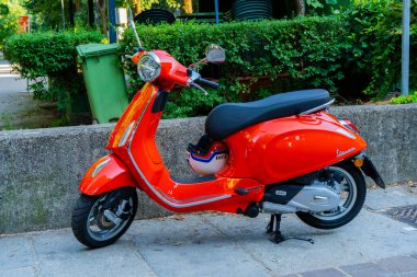 Vespa Primavera mobilet kırmızısı. Sokakta motosiklet. İtalyan mobilet. İtalya, Como - 17 Temmuz 2025