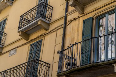 Ahşap panjurlu pencereler. İtalyan tarzı ön cephe mimarisinde balkon. Como şehri İtalya