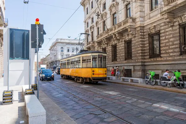 Eski sarı İtalyan tramvayı ve arabası yolda. Sokakta tramvay. İtalya, Milano - 17 Temmuz 2025