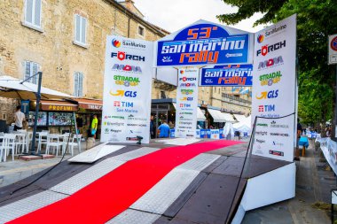 San Marino ralli şehri. Kürsüde kırmızı halı. Sponsorların logoları, reklam panoları. İtalya, San Marino - 13 Temmuz 2025