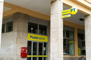 Poste Italiane ön cephedeki İtalyan postanesinin penceresi. Bina girişi. Sarı logo işareti. İtalya, Rimini - 13 Temmuz 2025