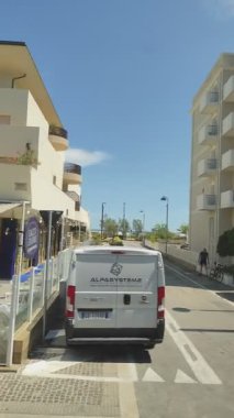 Yazın tatil köyünün ilk hattındaki otellerin yanından geçerek yol boyunca araba sürmek. Arabadan bak. İtalya, Rimini - 21 Haziran 2025