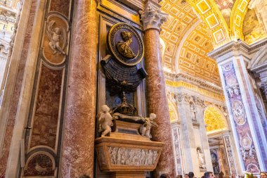 Vatikan Şehri, Vatikan - 12 Temmuz 2025: St. Peter Bazilikası iç mimarisi, kırmızı mermer sütun. İsveçli Christina 'nın anıtı. Kilise içeride. Eski mimari. Din turizmi.