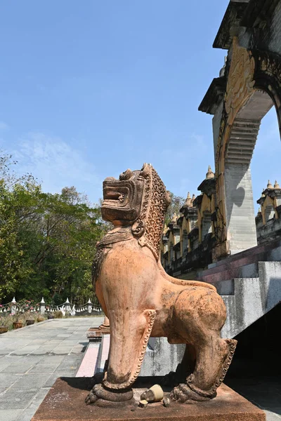 A statue of a lion guarding in front of the temple entrance door.