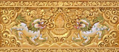 Kutsal Budist kilise duvarına efsanevi aslanın güzel altın oyması. 