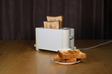 Kahvaltı için dilimlenmiş sıcak ekmeğin yakın plan resmi. Masadaki beyaz tost makinesinde.