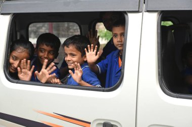 SAVATTHI, INDIA - 13 Kasım 2024: Kimliği belirsiz üniformalı öğrenciler okuldan sonra okul otobüsüyle evlerine dönüyorlar 