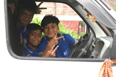 SAVATTHI, INDIA - 13 Kasım 2024: Kimliği belirsiz üniformalı öğrenciler okuldan sonra okul otobüsüyle evlerine dönüyorlar 