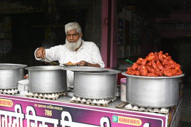 Shravasti, India November 15, 2024:Muslim male vendors cooking and selling foods clipart