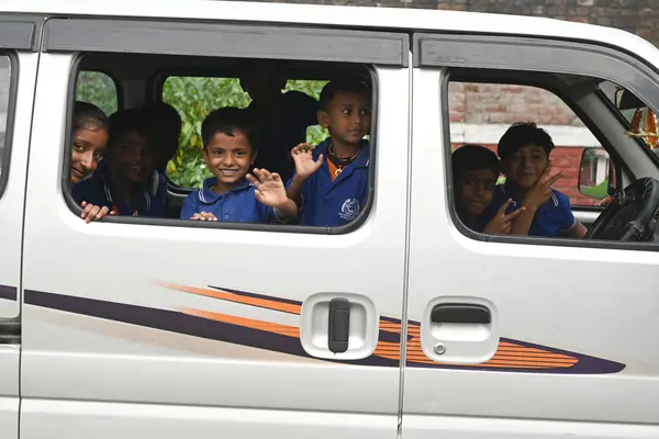 SAVATTHI, INDIA - 13 Kasım 2024: Kimliği belirsiz üniformalı öğrenciler okuldan sonra okul otobüsüyle evlerine dönüyorlar 