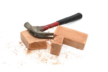 Parçalanmış tuğla parçaları ve beyaz arka planda izole edilmiş bir çekiç.