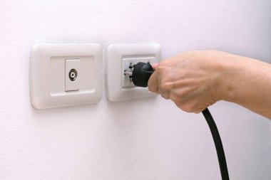 Bir elektrik prizini duvardaki elektrik prizine bağlamak için el tutuşu prizi..