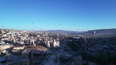 Drone bakış açısı, sıcak hava balonlarının sabahları Cappadocia 'nın görkemli volkanik manzarasının üzerindeki görüntülerini gösteriyor. Goreme Ulusal Parkı. UNESCO Dünya Mirası sitesi. Nevsehir ili, Türkiye