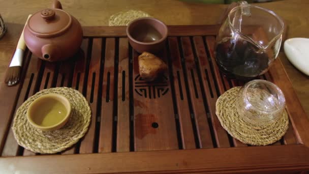 プーアル茶の醸造 伝統的な中国茶の儀式 ティートレイにティーポットに注ぐ ムーディー低キー選択的フォーカス — ストック動画