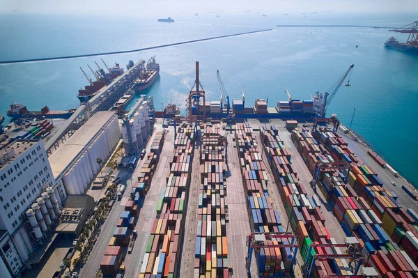 Cargo logistics terminal in international sea port. Aerial view of gantry cranes, cargo ships and containers. Mersin International port, Turkiye.