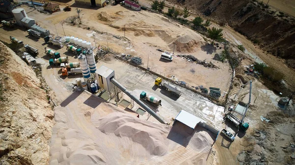 Aerial view of crushed stone quarry machine. Producing of construction materials at open pit limestone mine. Stone crushing plant. Cone type rock crusher