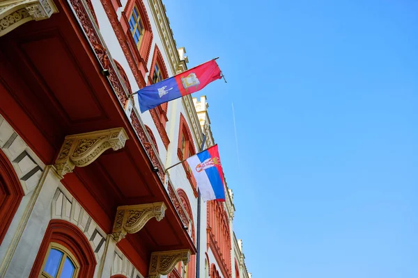 ベオグラード大学のレコータ建築のファサードにフラグ 歴史的建造物のファサードにセルビアの国旗 低角度表示 — ストック写真