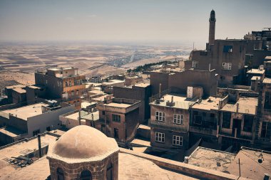 Türkiye 'nin mezopotamya kenti Mardin' in çatıları, camileri ve tarihi binalarının panoramik manzarası. Arka planda Mardin 'in Mezopotamya ovasının karşısındaki çatılar