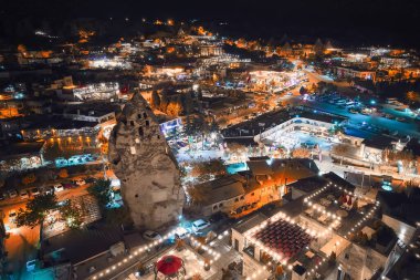 Nevsehir ilinin Goreme köyündeki aydınlık caddelerin, peri bacalarının ve mağara otellerinin hava manzarası, Kapadokya, Türkiye