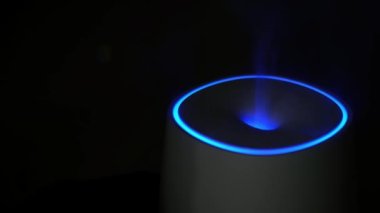 Air humidifier with bright lighting against dark background