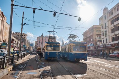 Mavi tramvaylar. Tramvay durağındaki insanlar. İskenderiye, Mısır - Mart 2023