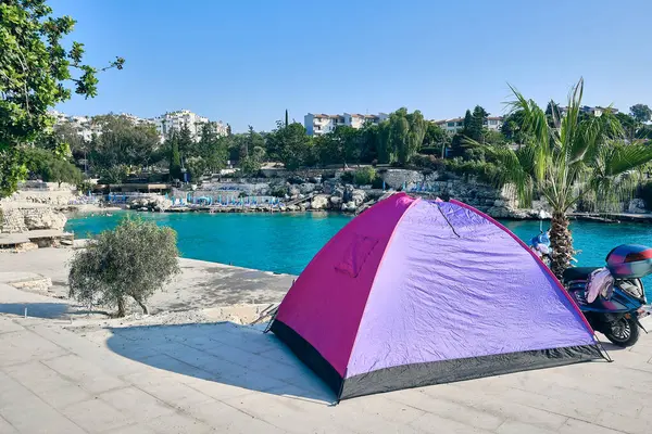Tourist tents on a cliff in sea lagoon. Summertime camping at seaside. Summer campground