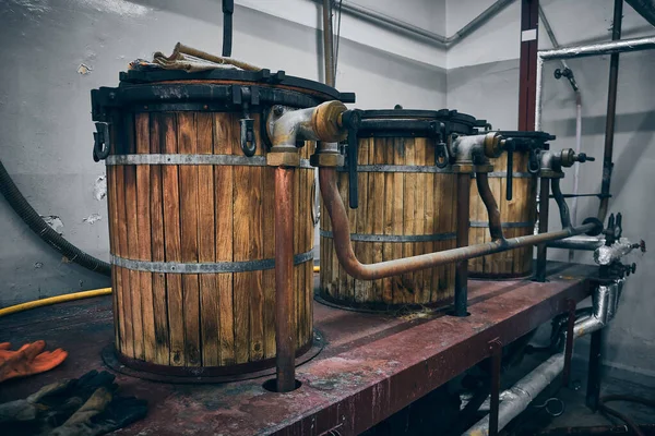 ワイン生産設備 ワイナリーの古い木製樽とパイプライン — ストック写真