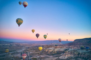 Kapadokya 'nın görkemli volkanik manzarasının üzerindeki sıcak hava balonlarının insansız hava aracı bakış açısı. Goreme Ulusal Parkı. UNESCO Dünya Mirası sitesi. Nevsehir ili, Türkiye
