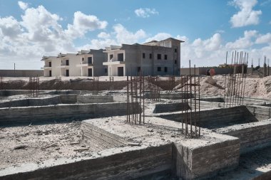Sert beton temeller ve konut binasının dikey demirleri. İnşaat alanında sürekli zemin