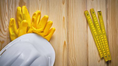 Saf eldivenler, beyaz kasket ve ahşap parkmetre tahta yüzeye uzanıyordu. İnşaat mühendisi ekipmanı