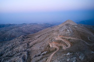 Sunrise above Nemrut Mount. Aerial view. Eastern terrace of Nemrut Mount, Adiyaman province, Turkey. UNESCO World Heritage Site clipart